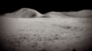Animation showing a rain of tiny, forceful impacts on the Moon’s surface. Each one creates a brief flash of light and kicks up a cone of grey dust. In the background, light grey mountains are under a black sky.