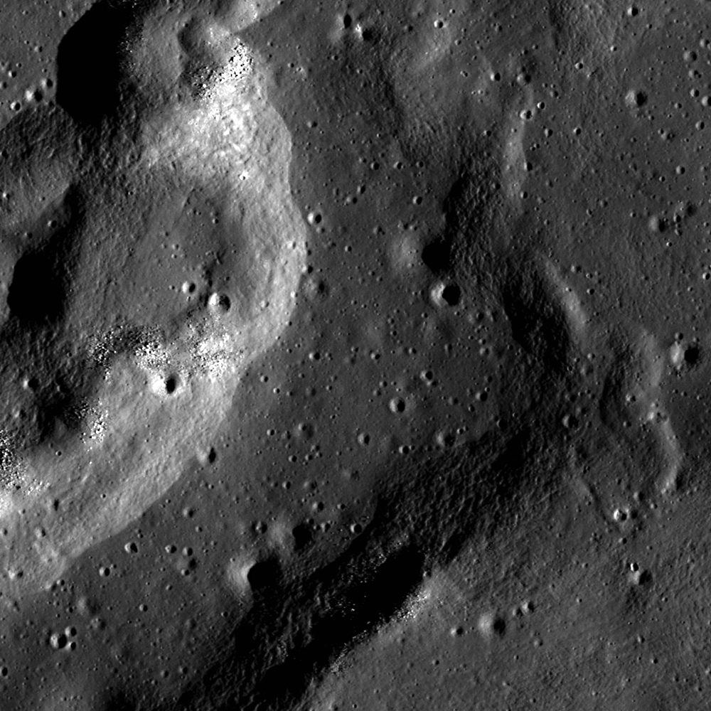 Overhead view of a pockmarked landform on the Moon. Light catches the curved edge of the ridge on the left; its right edge is in shadow.