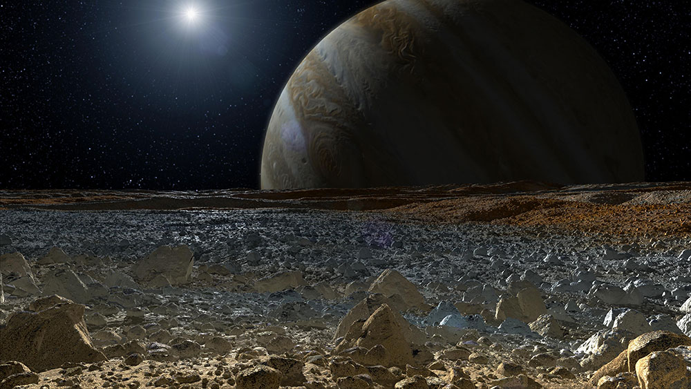 This artist's concept shows a simulated view from the surface of Jupiter's moon Europa. Europa's potentially rough, icy surface, tinged with reddish areas that scientists hope to learn more about, can be seen in the foreground.