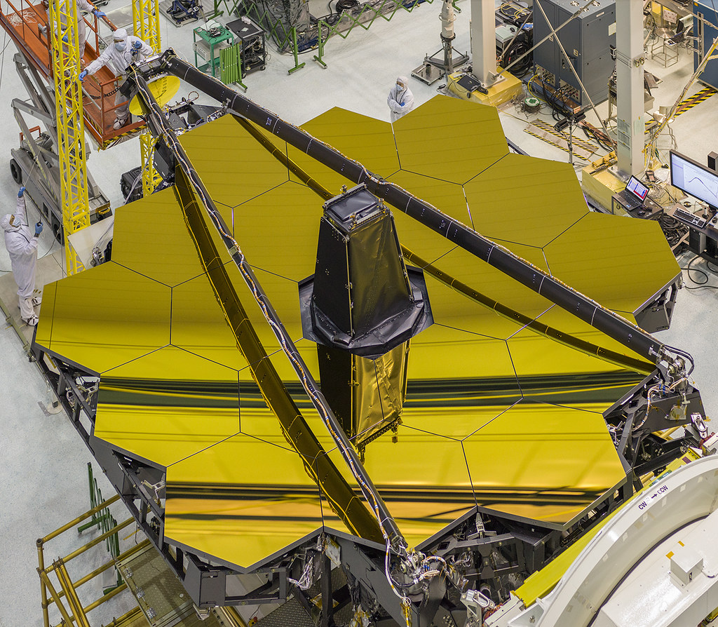 An overhead image of the golden James Webb Space Telescope, with its secondary mirror booms stowed
