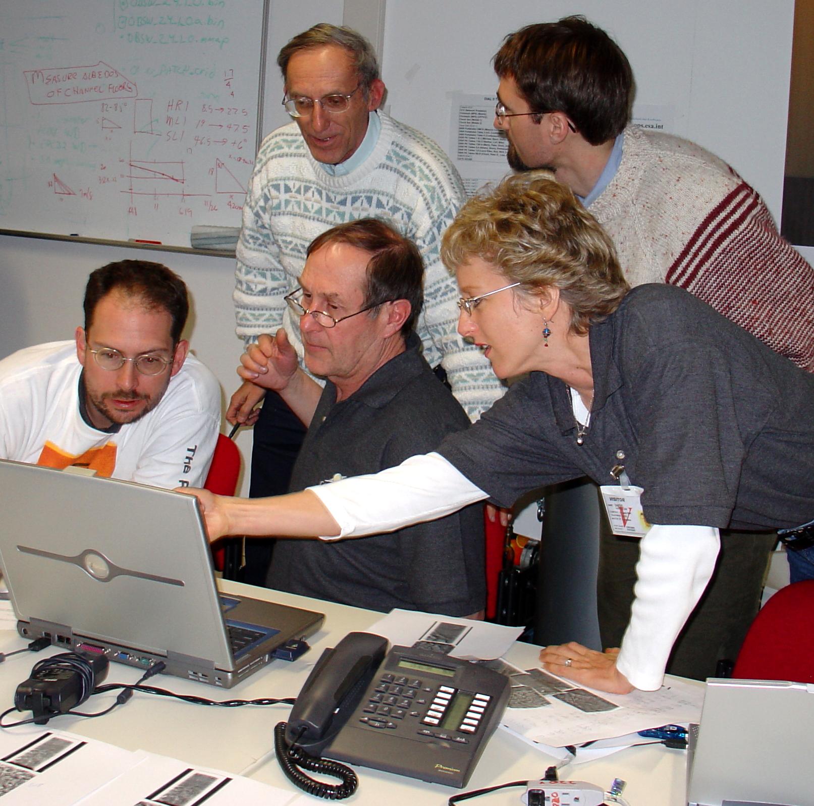 Five scientists gathered around a laptop looking at Huygens data
