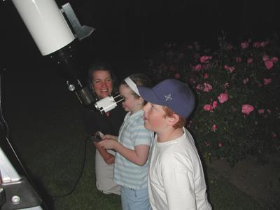 People taking turns looking through a telescope