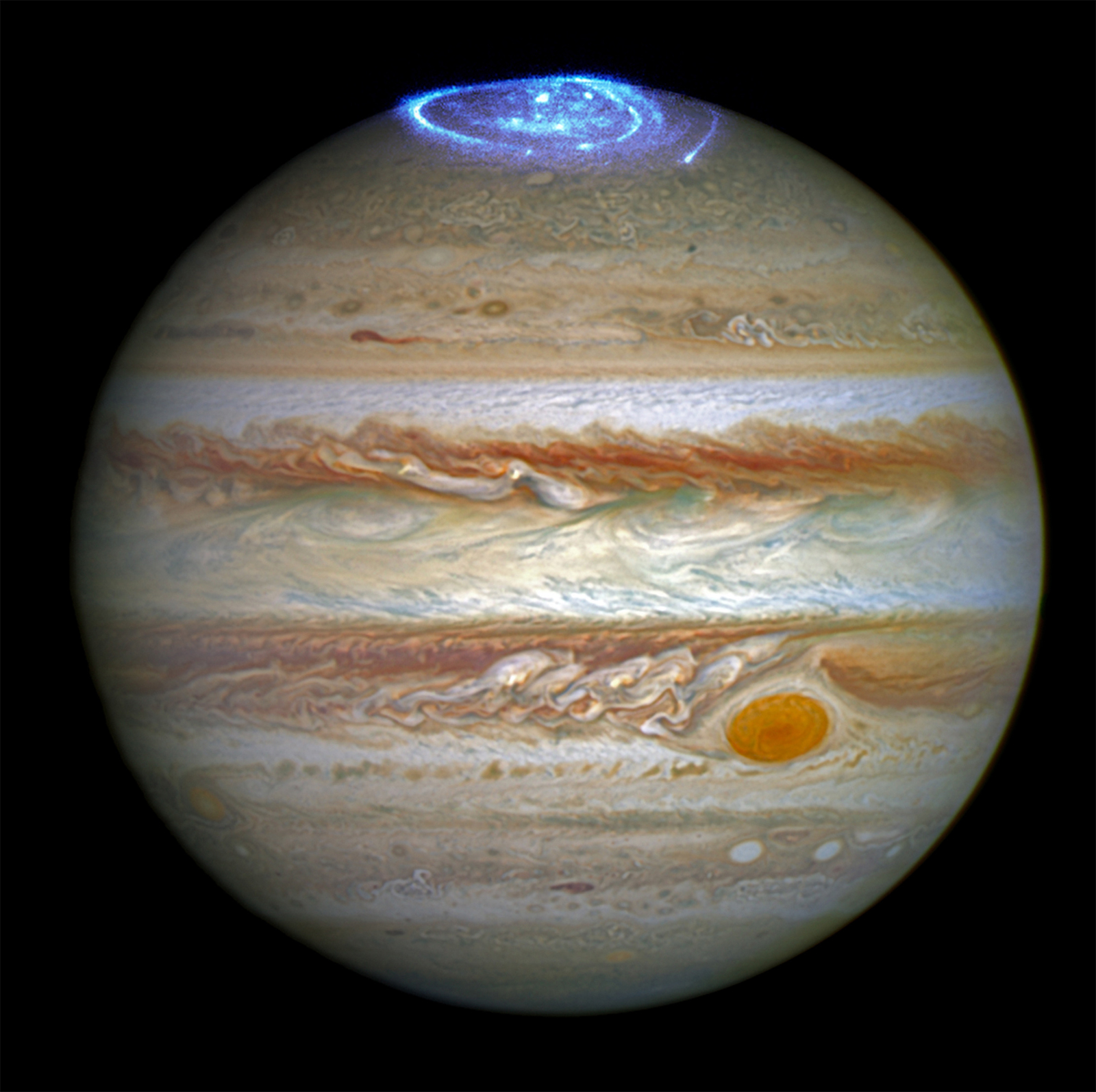 Jupiter is topped with a glowing blue aurora in this enhanced, full-disk image of the gas giant planet.