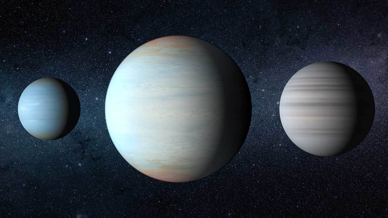 Three exoplanets are shown, with two smaller planets around the third much larger planet.