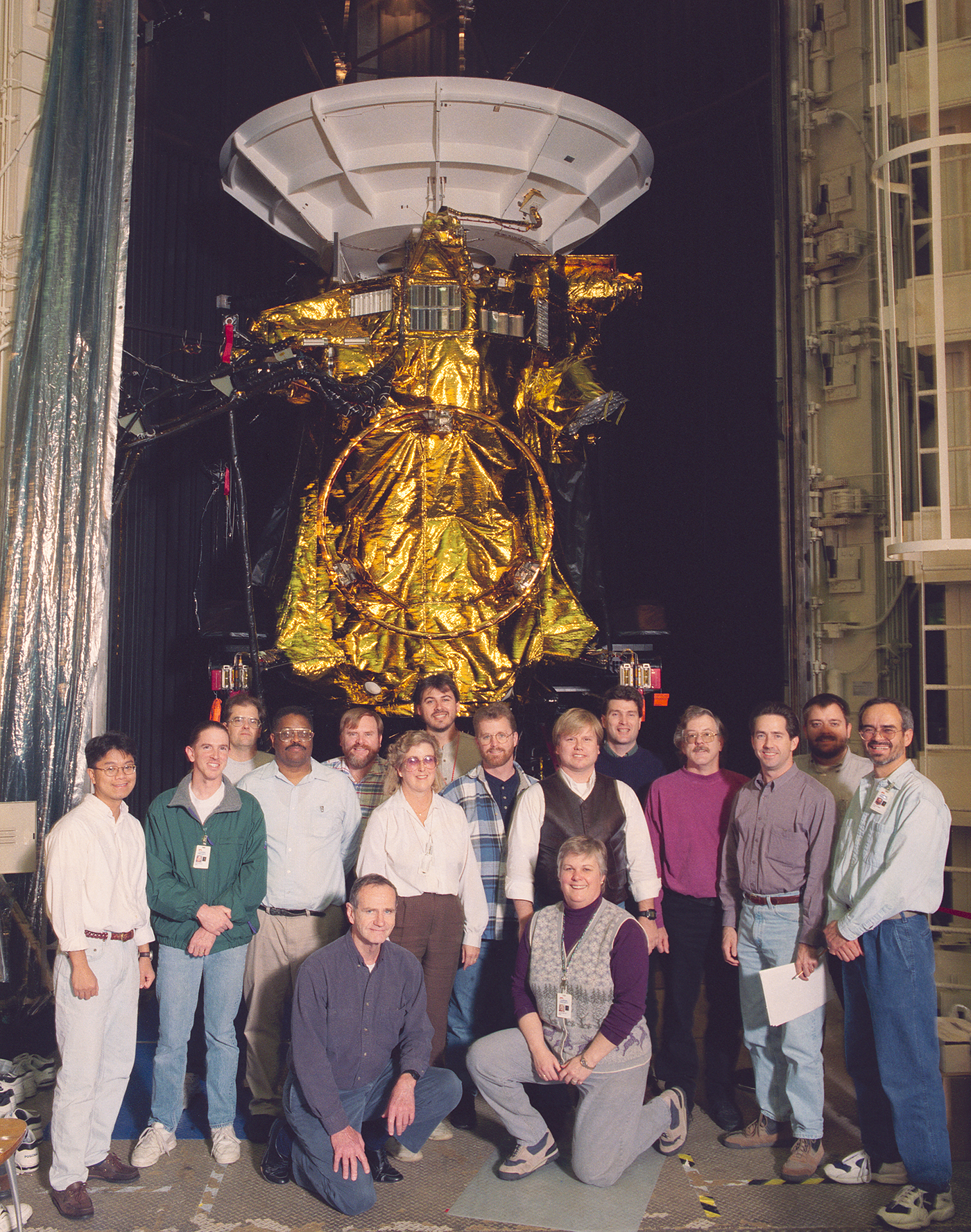 Group of people in front of spacecraft.