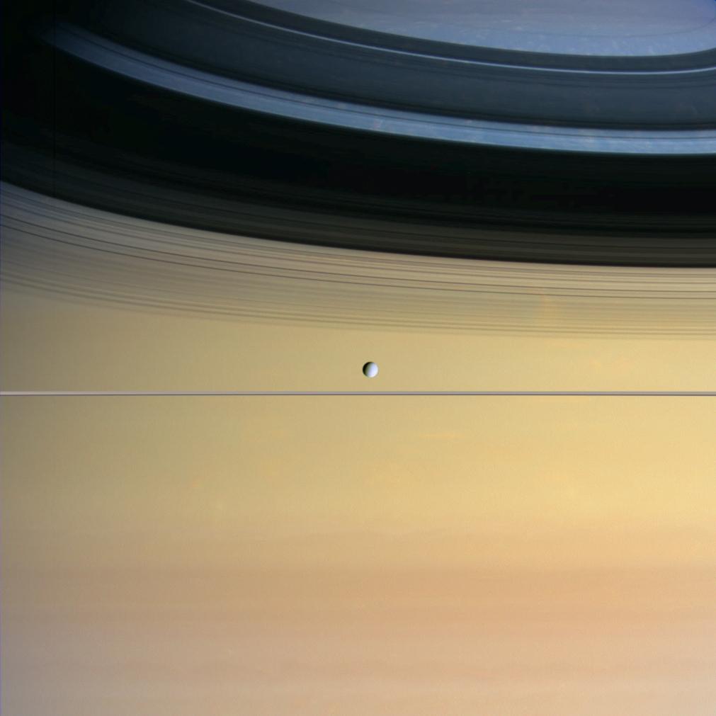 Saturn's small moon Dione with Saturn imposing in the background