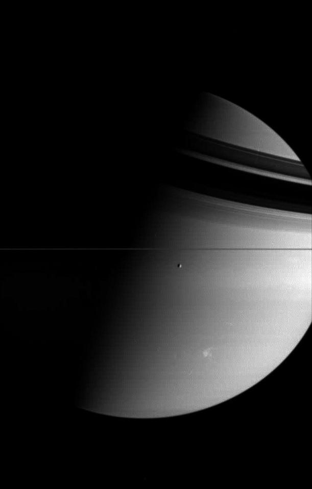 Saturn and its moon Tethys, while a large and powerful storm rages in the planet's southern hemisphere