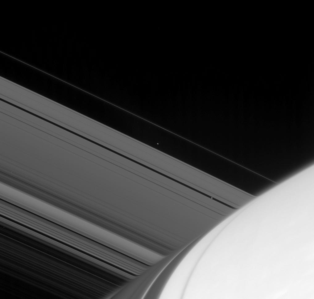 Atlas and Pan emerge from the far side of Saturn