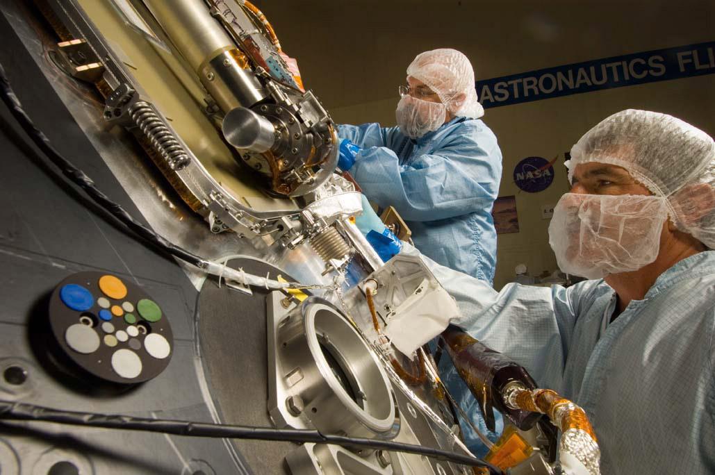 Lockheed Martin Space Systems technicians Jim Young (left) and Jack Farmerie (right) work on the science deck of NASA's Phoenix Mars Lander.