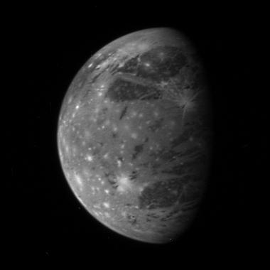 Grayish moon Ganymede with bright spots.