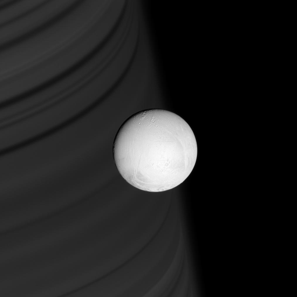 Enceladus in front of a backgdrop of Saturn's rings
