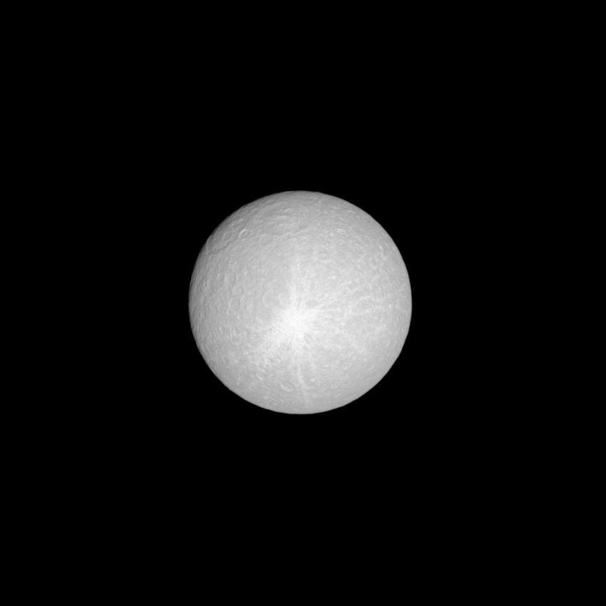 Lit brilliantly by the sun, the moon Rhea shows off its huge ray crater.