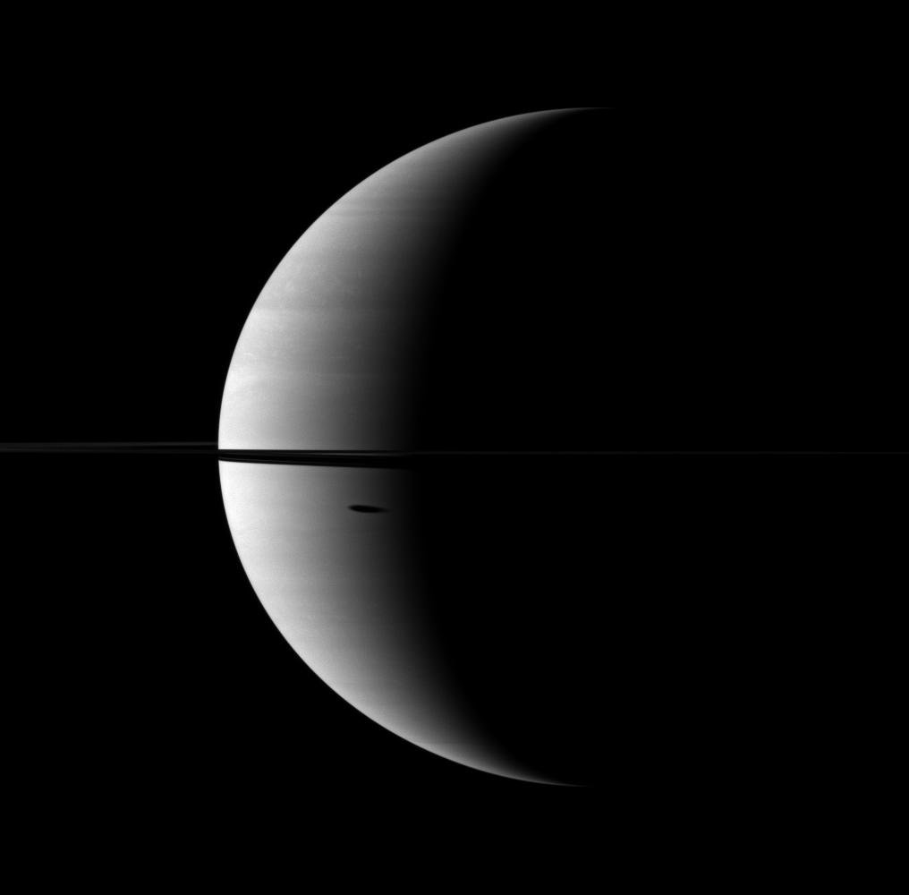 The shadow of Saturn's moon Dione, cast onto the planet, is elongated in dramatic fashion.
