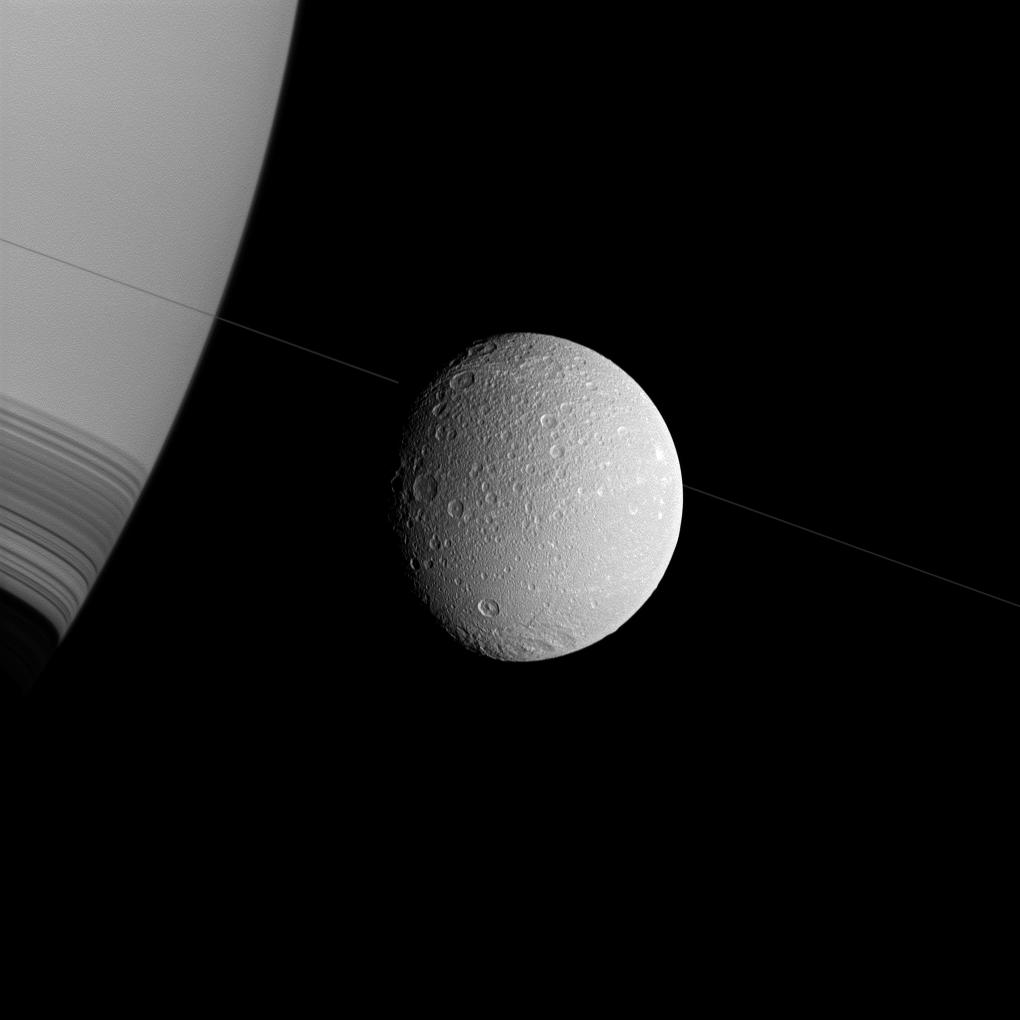 Saturn, Dione and the thin diagonal line of the planet's rings