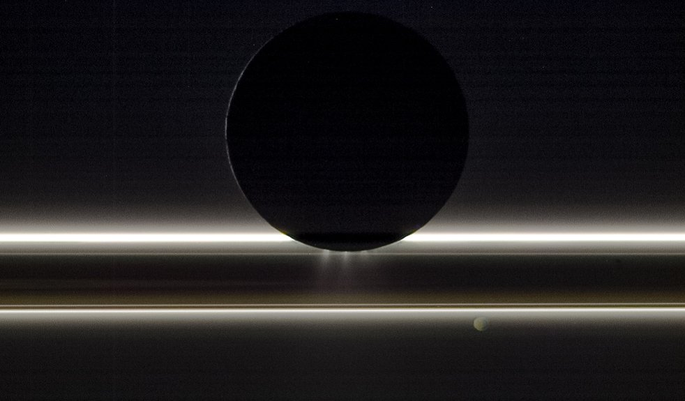 A backlit view of Enceladus and Saturn's rings