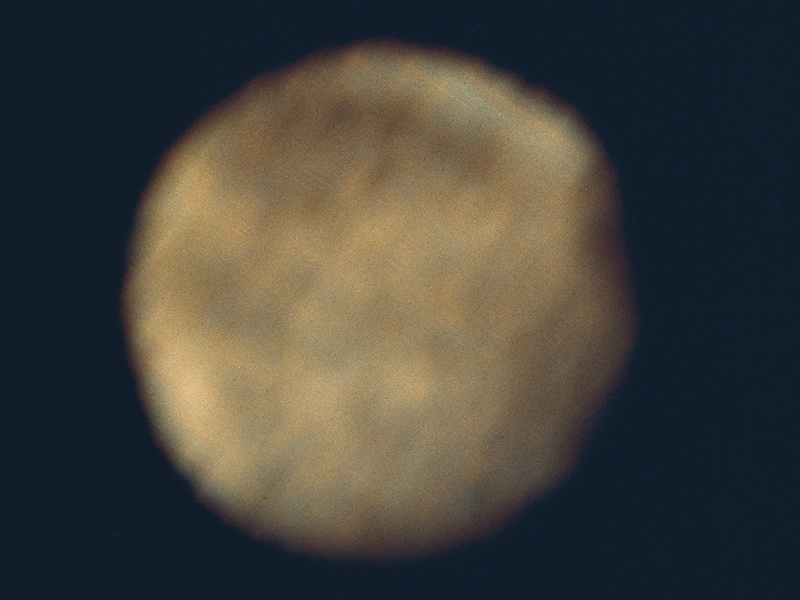 Jupiter's moon Ganymede appears fuzzy, and yellowish in this image taken by the Pioneer 10 spacecraft.