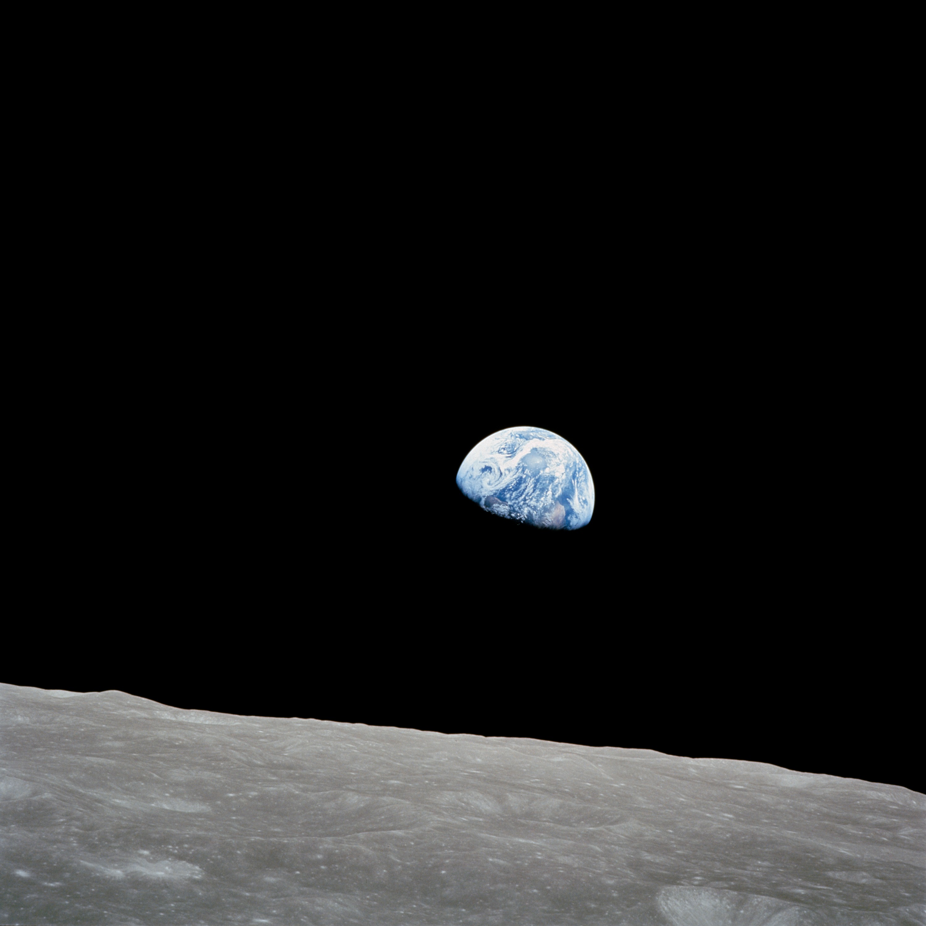 blue earth in black space above gray lunar surface