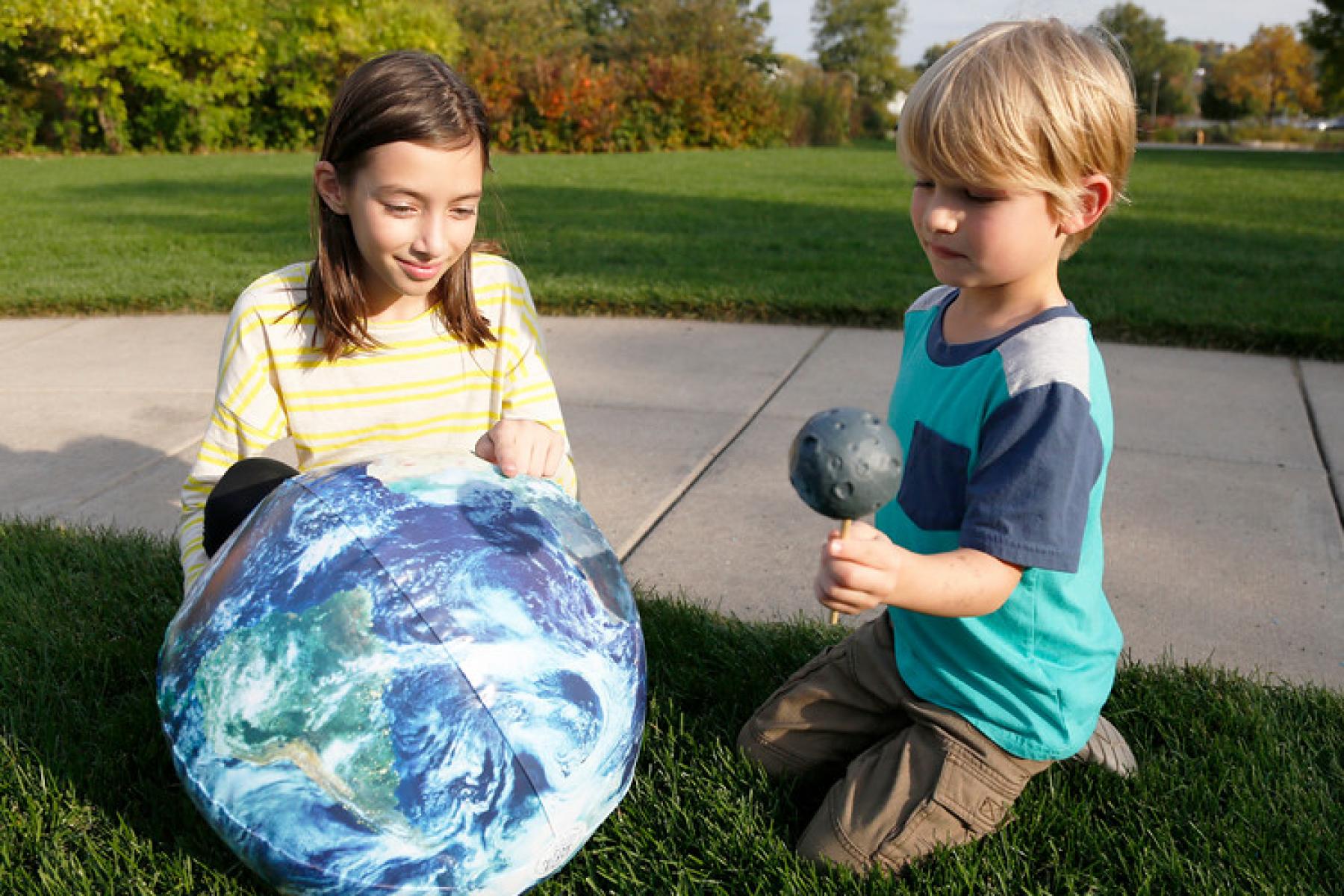 children use a beach ball to learn about solar eclipses