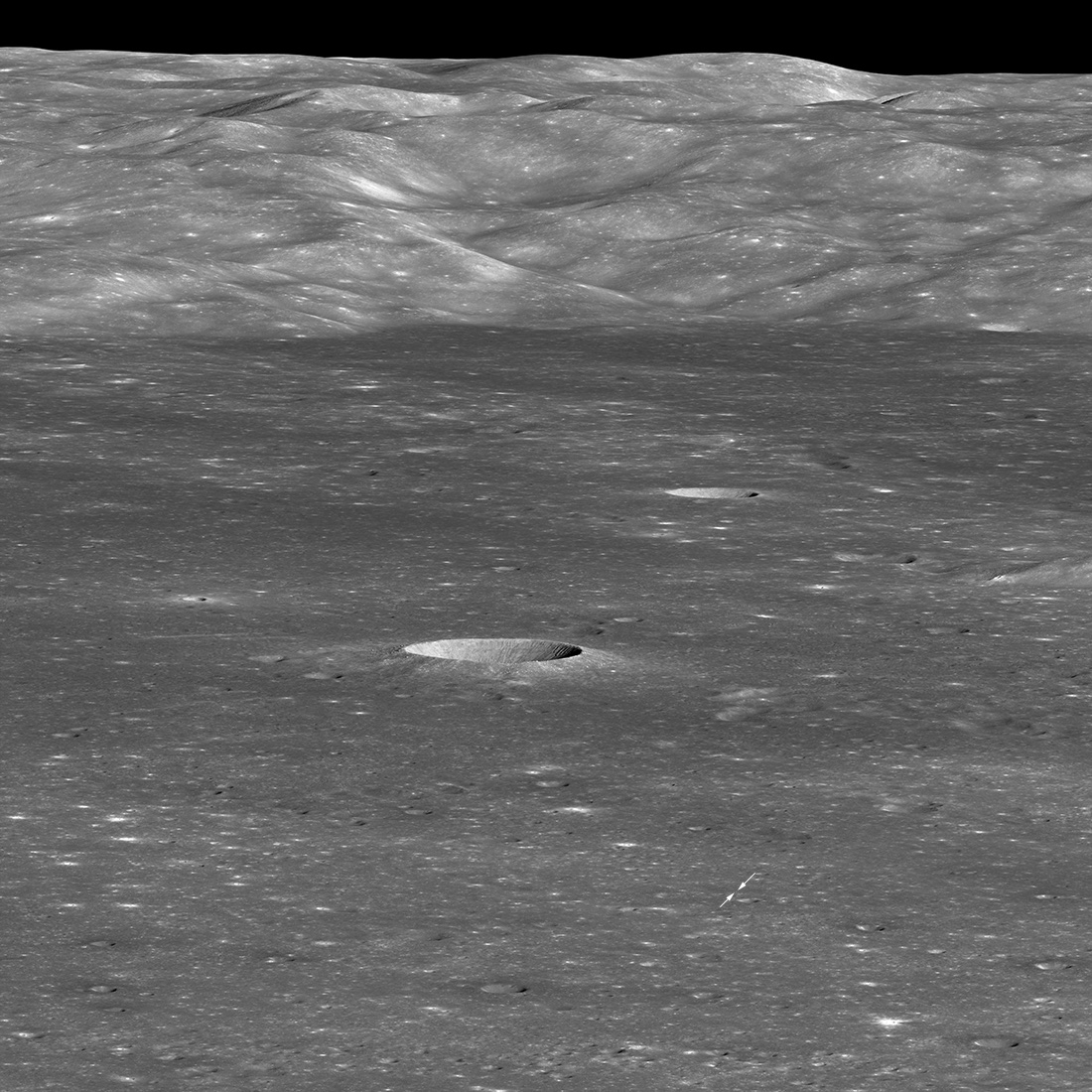 oblique view of large crater with arrows marking spot of landing