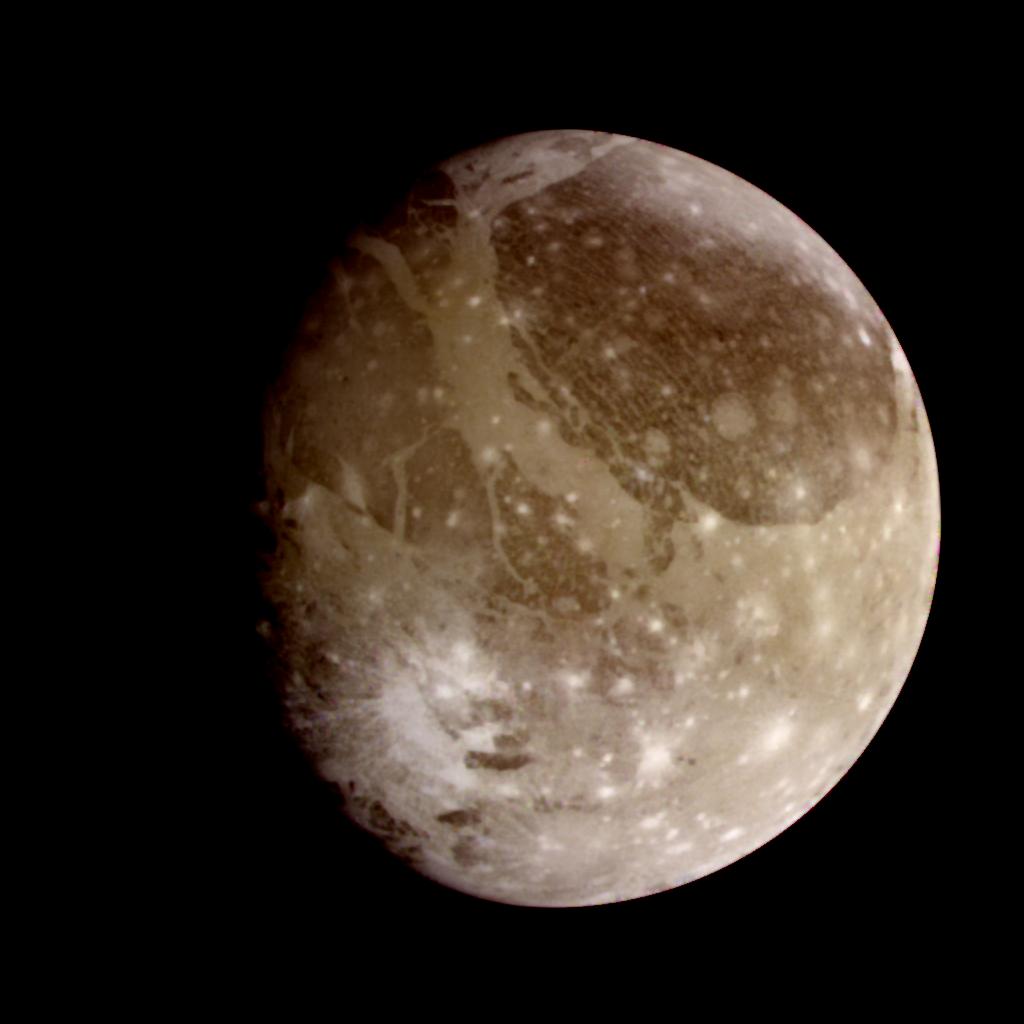 Jupiter's moon Ganymede appears brownish gray with white splotches.