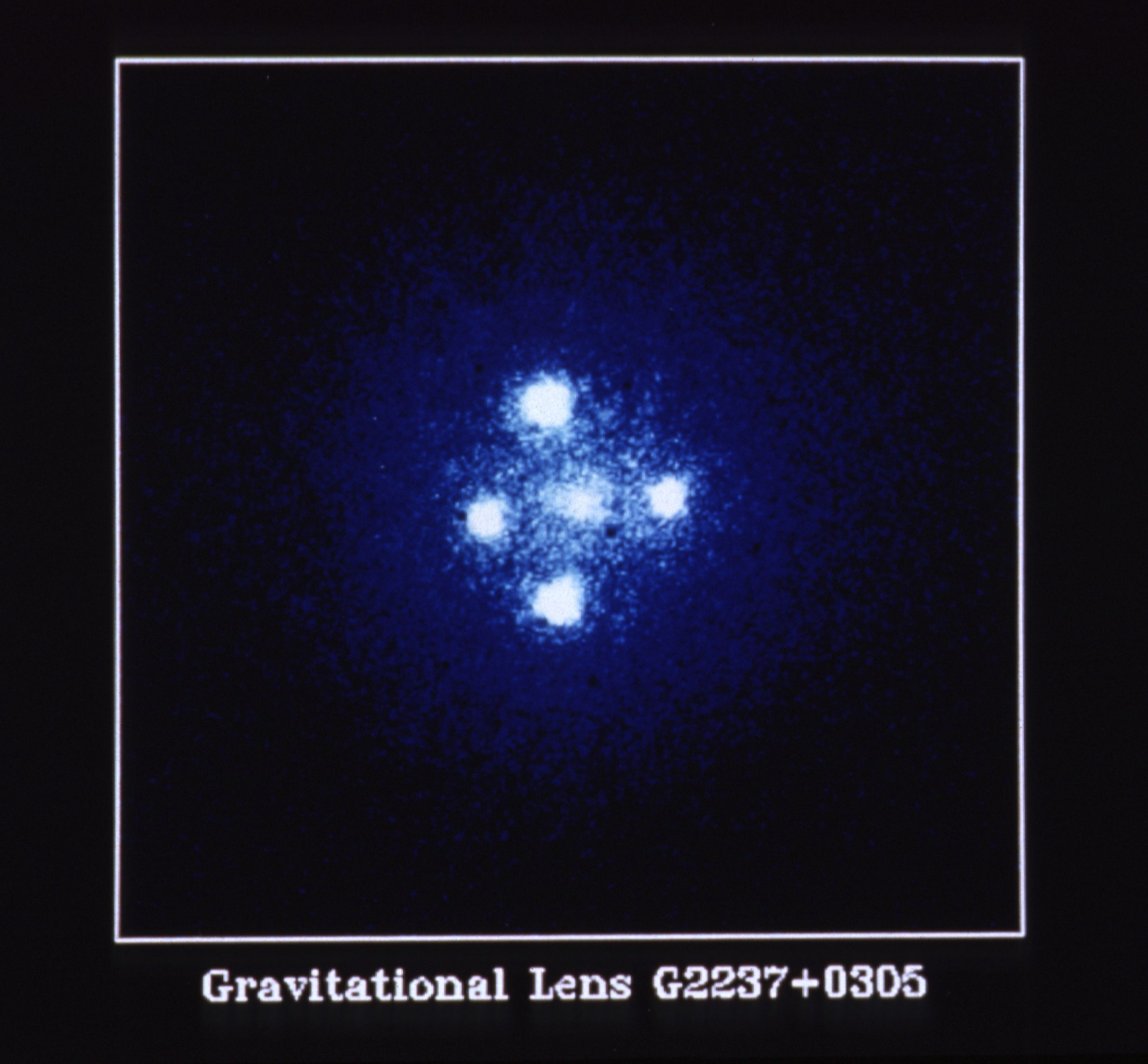 Five bright points of blue-white light. The center point is the galaxy. The four other points are above, below, and left, and right of the center.