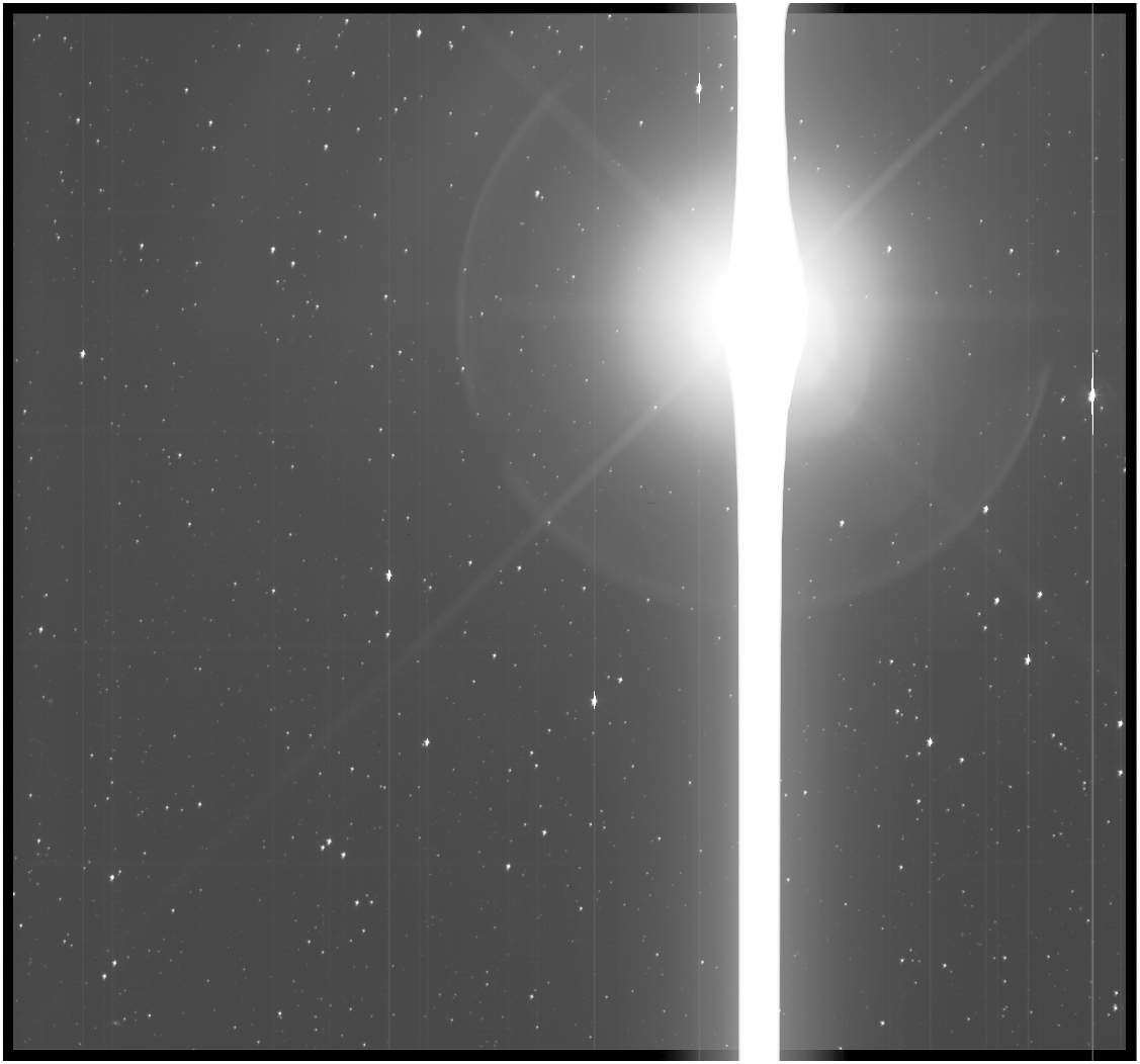 Black and white view of Earth as a bright lens flare against a background of stars.