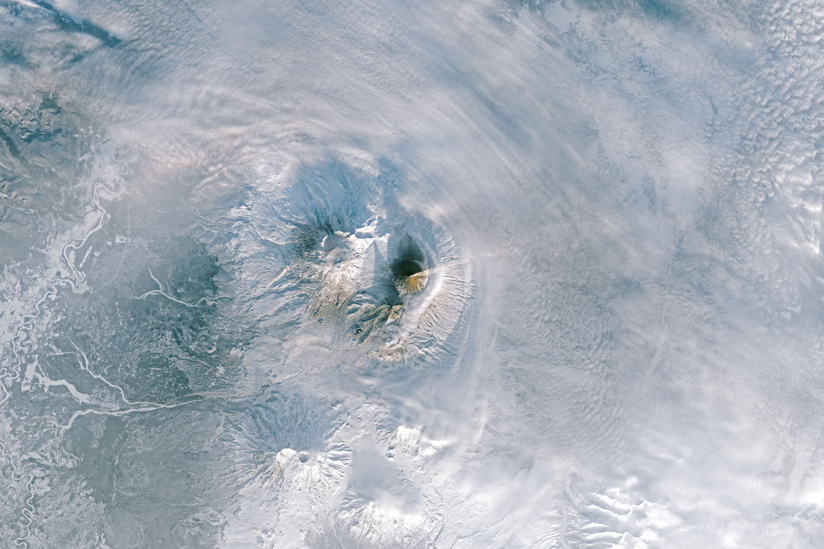 erupting volcanoes in snowy landscape seen from directly above