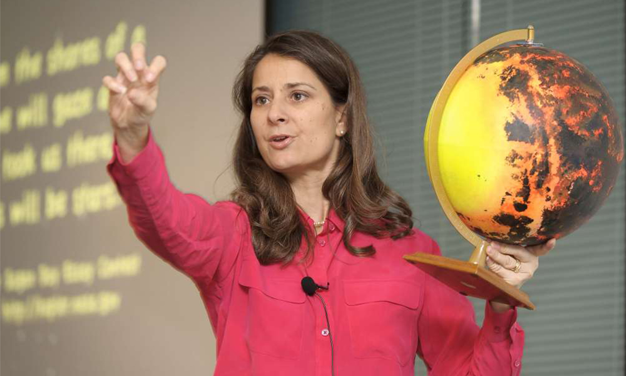 Photo of Natalie Batalha holding a model of an exoplanet she discovered.