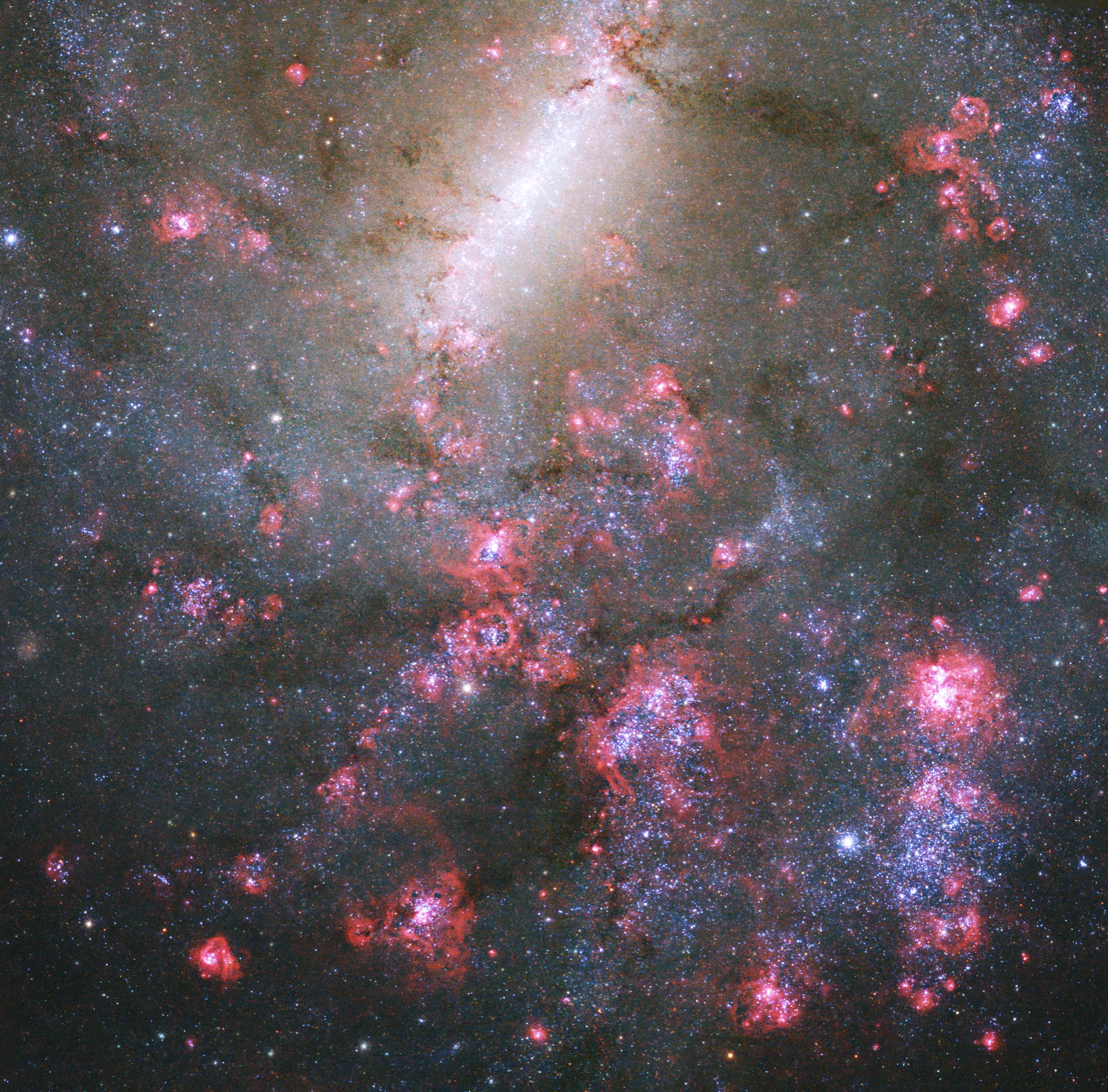 Splotches of bright-pink and blue-white fill the lower half of the image. A bright bar of white stars extends downward from top-center toward the left. Random areas of dusty clouds form dark streams against the bright backdrop.
