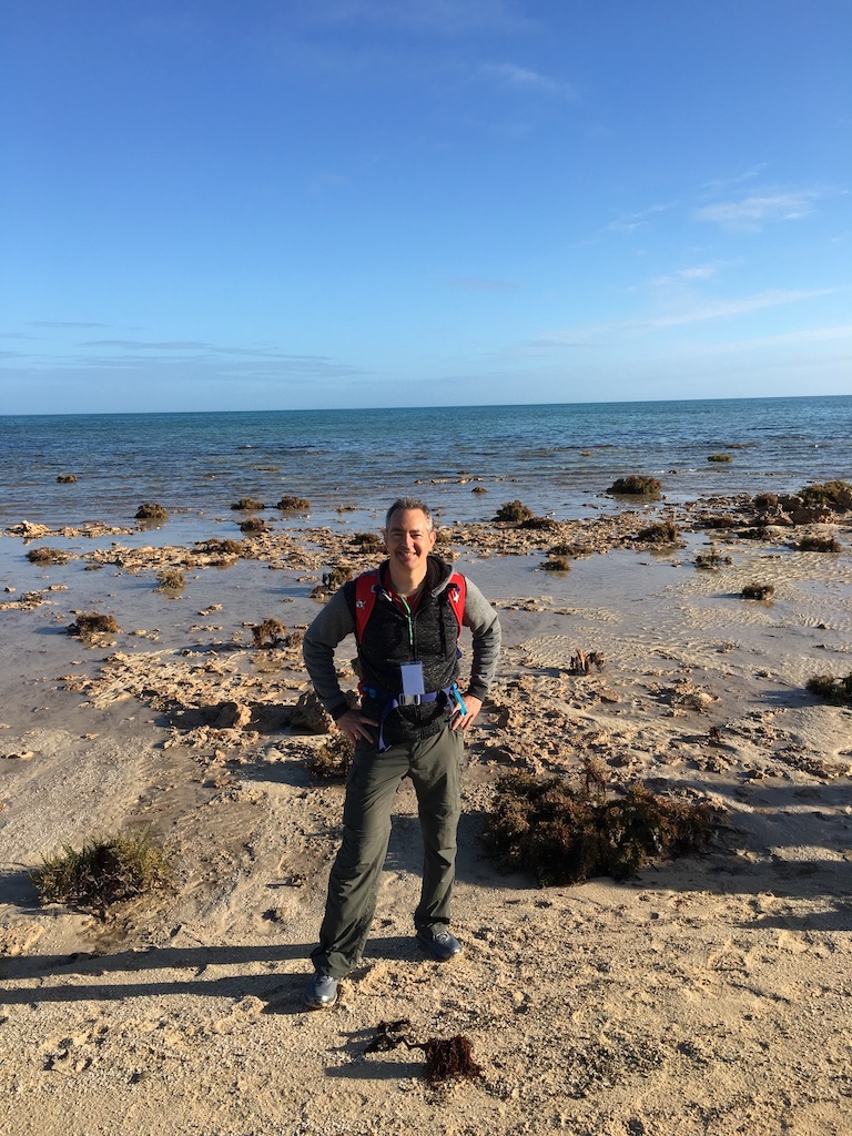 Nick Siegler, the chief technologist for NASA's Exoplanet Exploration Program, at Western Australia's Shark Bay. The dark, rounded forms in the background are stromatolites, one of Earth's most ancient lifeforms.