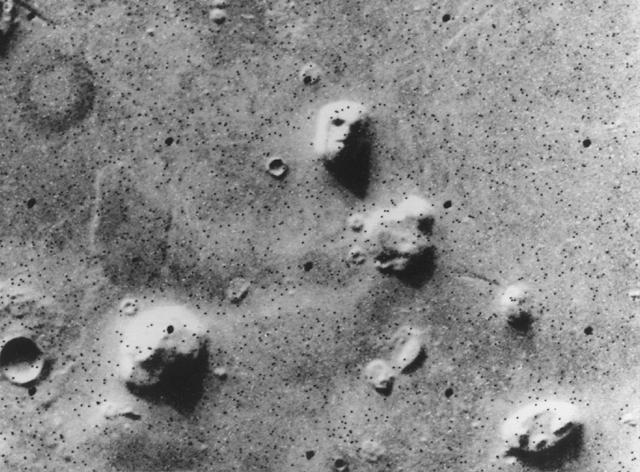 A series of hills on Mars shows what seems to be a face in this black and white photo. The face turned out to be shadows on the hill.
