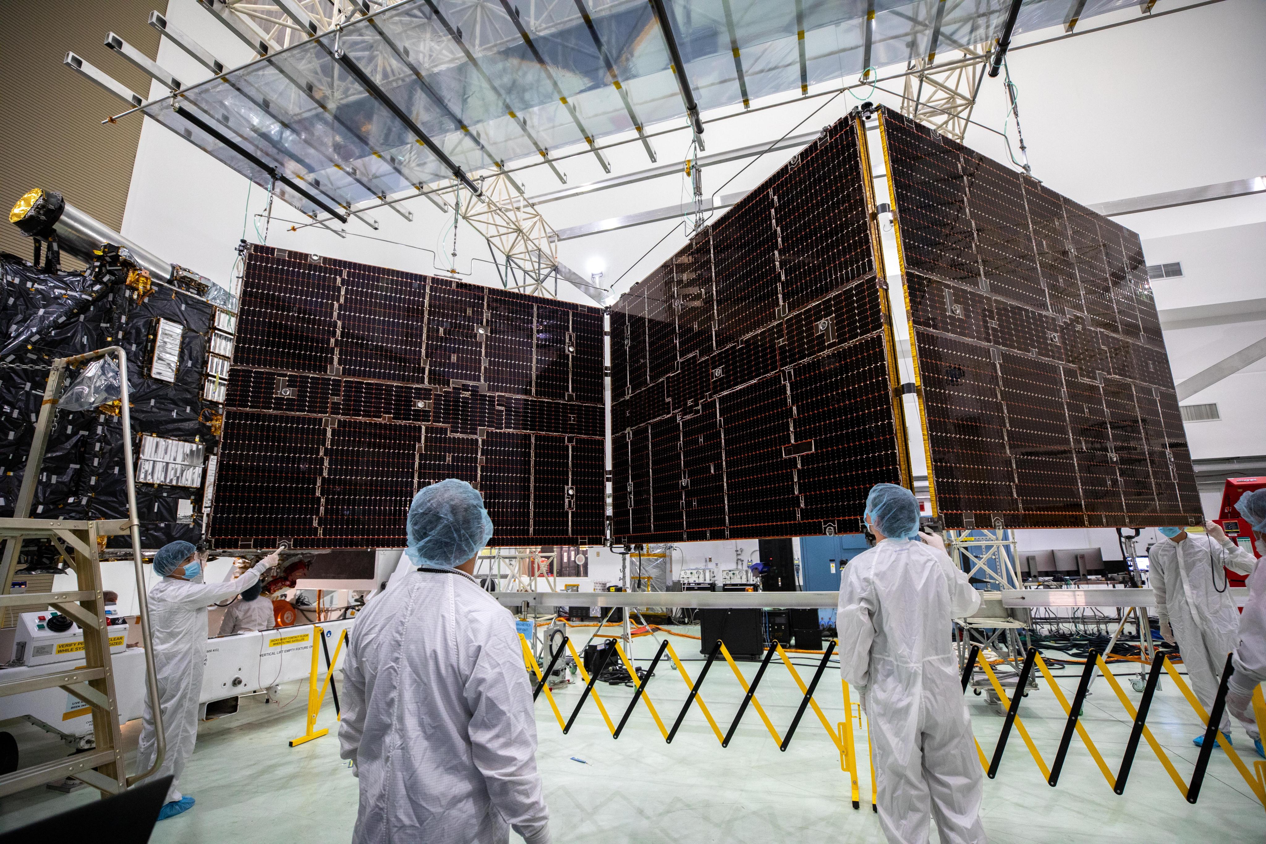 Workers stand near Psyche's solar panels