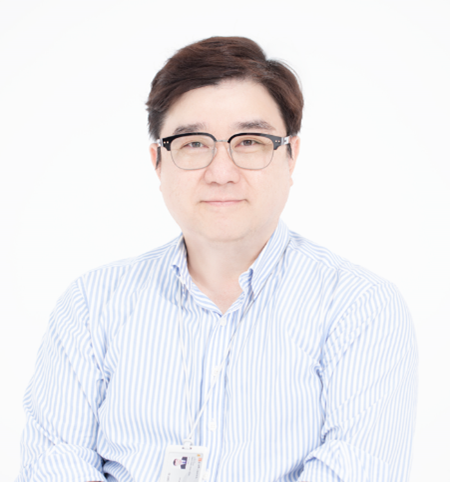 Portrait photo of a person with short hair wearing glasses a collared button-up striped shirt.