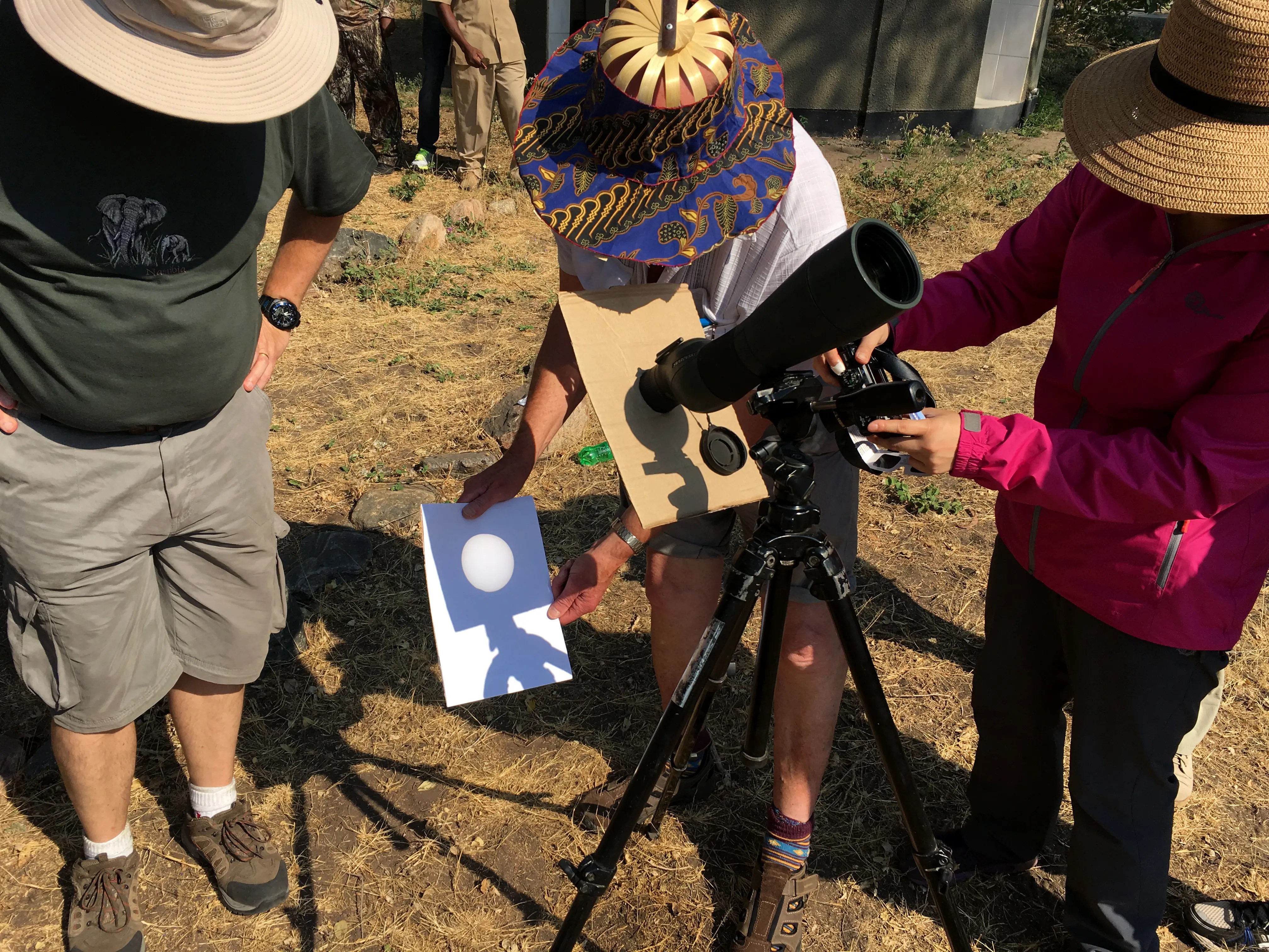 People projecting the sun through a telescope