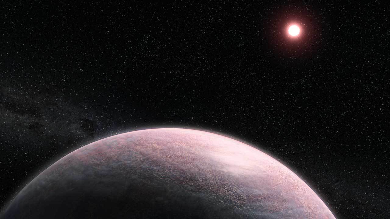 A reddish, terrestrial exoplanet is seen in orbit of its red dwarf star.