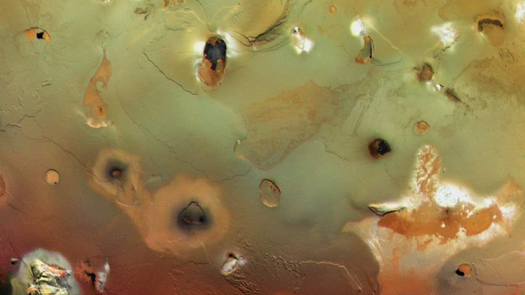 Collapsed volcanoes form large, dark spots on Io’s surface.