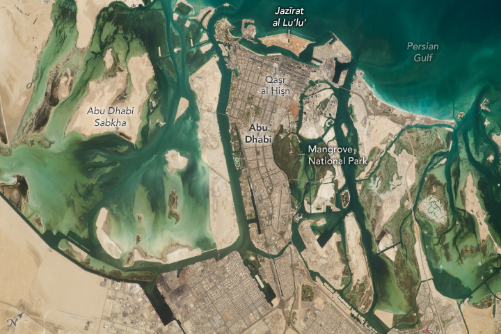 Intertidal flats, mangroves, and artificial islands surround the populous capital city of the United Arab Emirates.