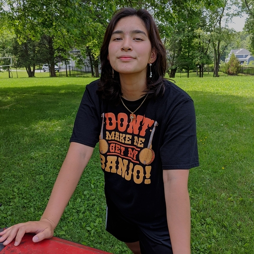 Photo of a young woman in a tshirt standing in a park