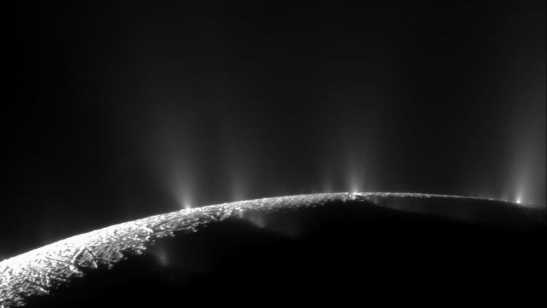 The limb of moon Enceladus with bright jets shooting material out into space