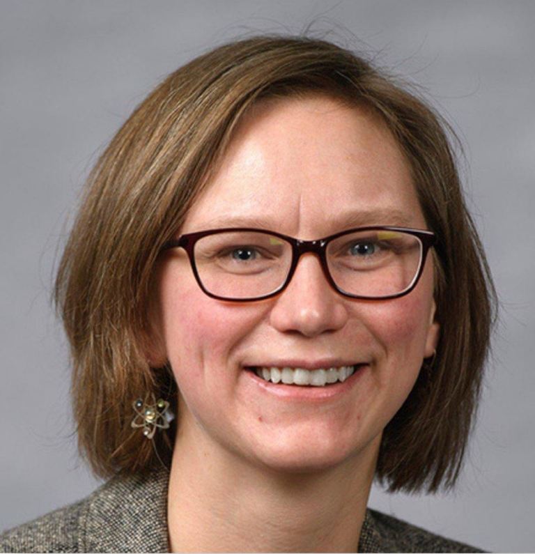 Portrait of Maren Mossman smiling in glasses with medium length hair.