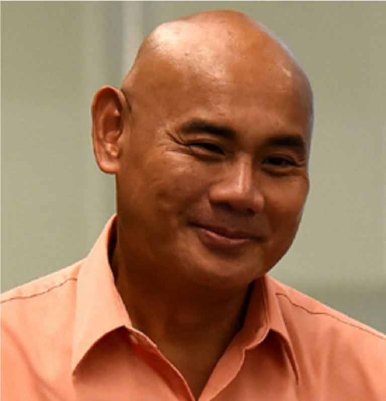 Dan Tagle smiling in a collared shirt.