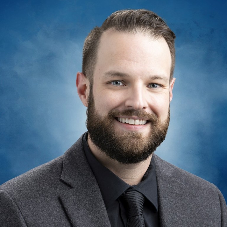 Portrait photo of a smiling man in a suit.