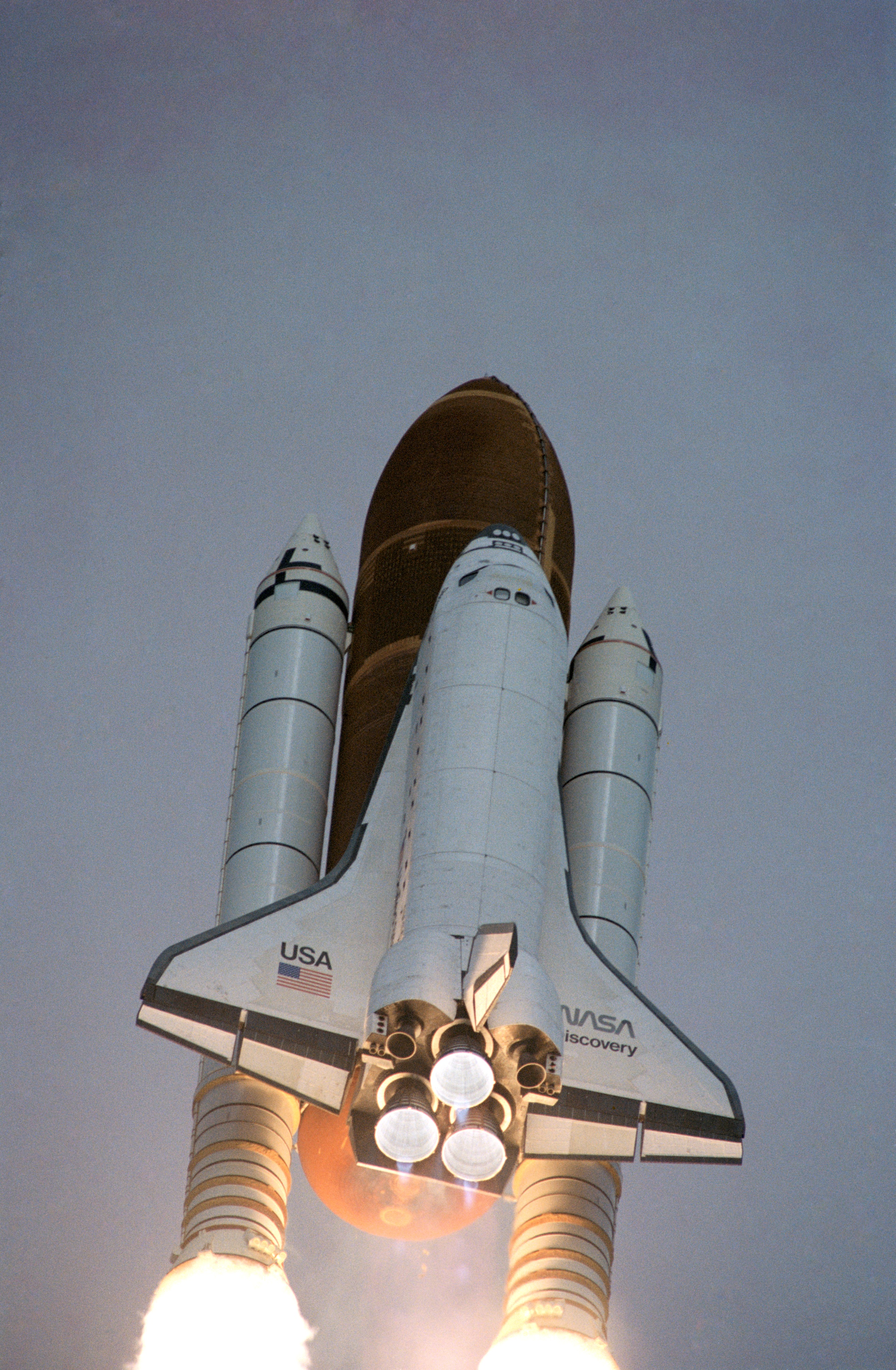 Looking up at the space shuttle Discovery as it climbs toward space.