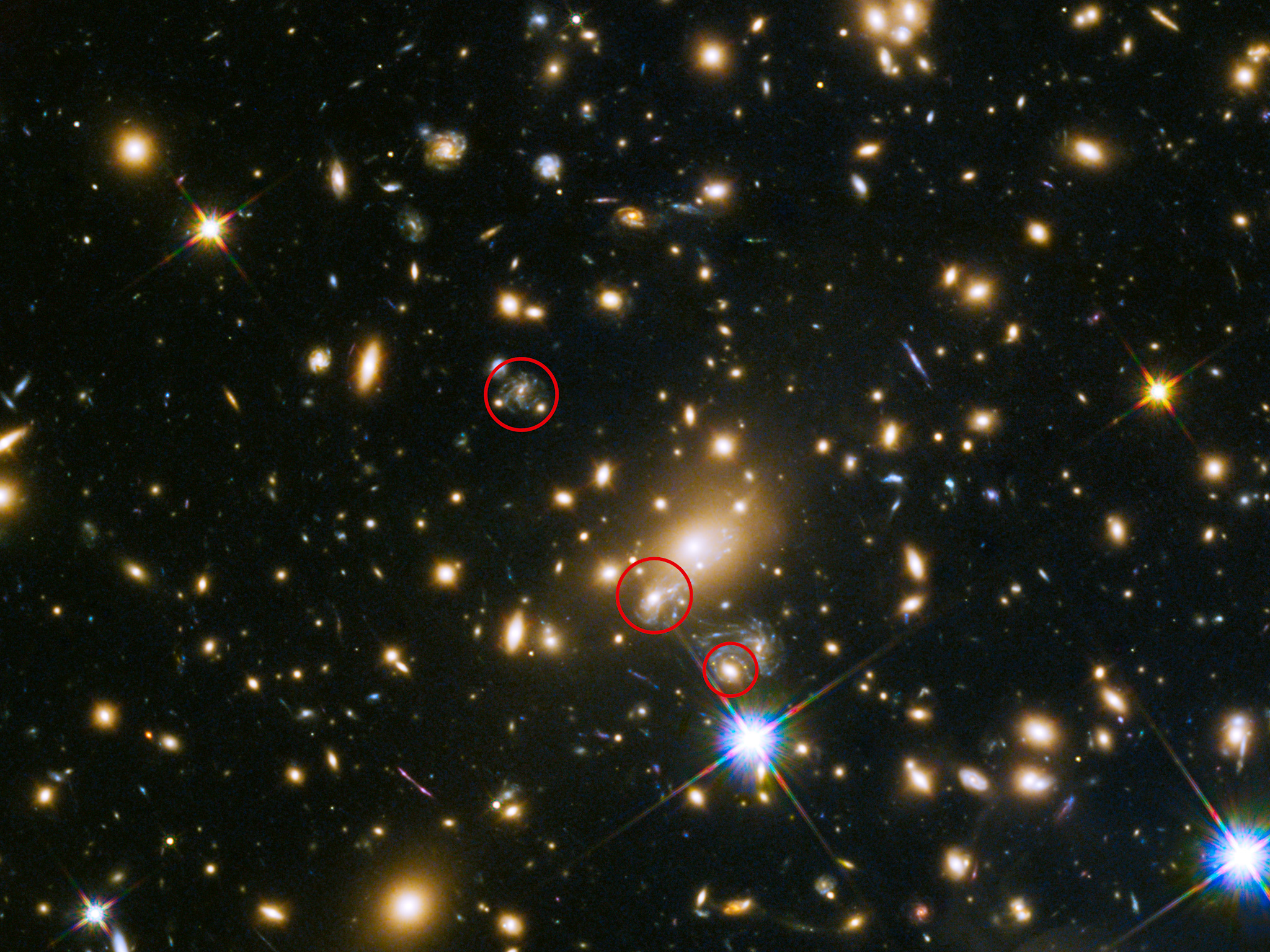 The field is filled with galaxies. One galaxy in particular is gravitationally lensed (circled in red) at least three times.