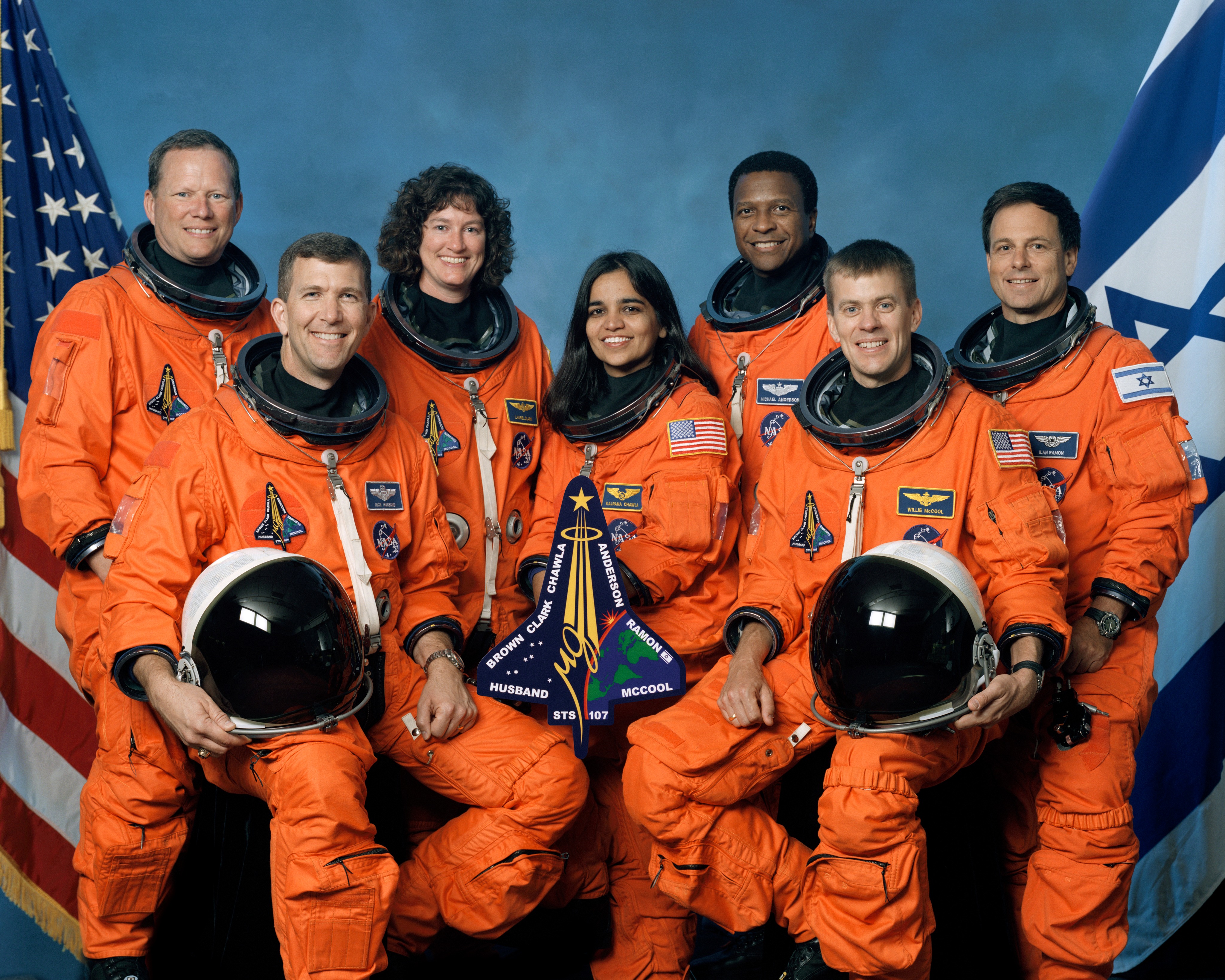 Eight astronauts in orange space suits.