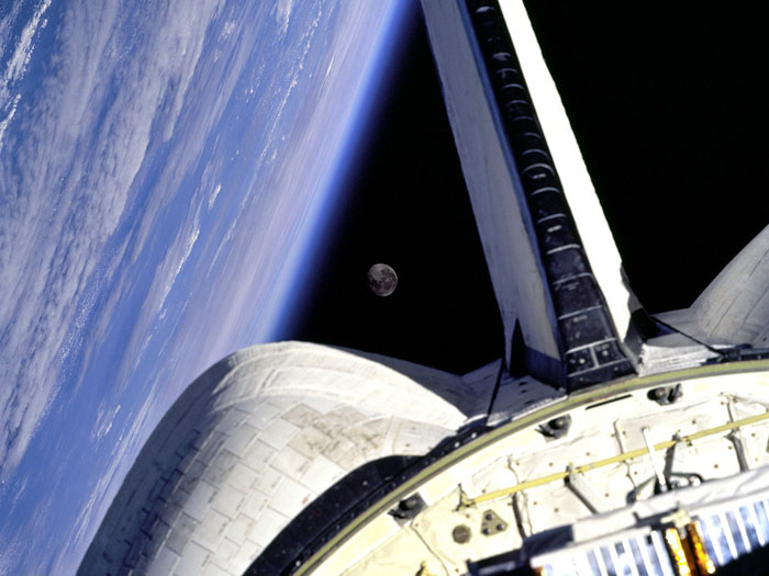 MOON FRAME: Earth and its Moon are nicely framed in this image taken from the aft windows of the Space Shuttle Discovery in 1998. Discovery, on mission STS-95, was flying over the Atlantic Ocean at the time this image was taken.