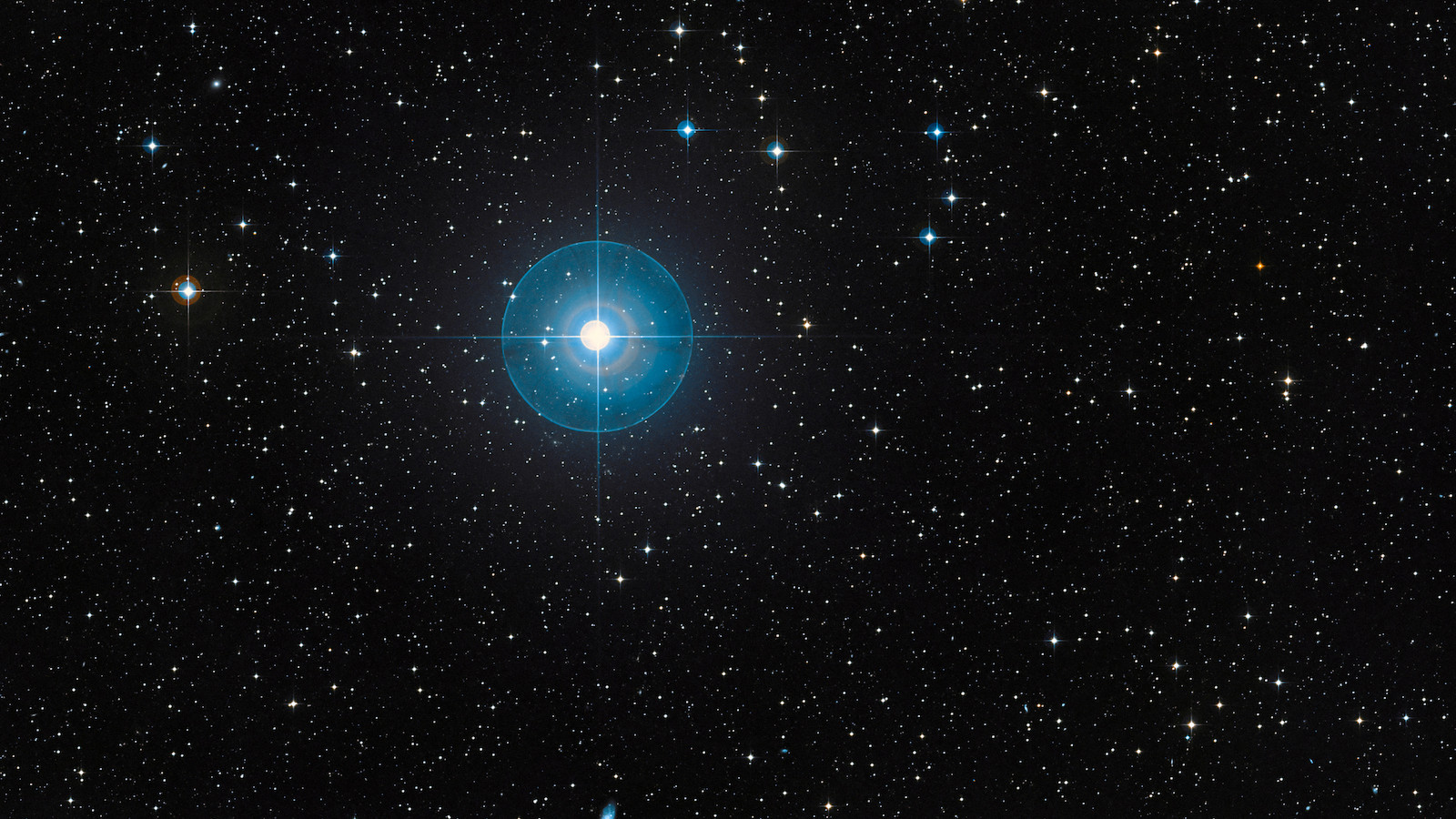 At the upper left of a dark, star-filled sky is a bright, bluish light. It is the star Beta Pictoris with a glow around it showing the surrounding disk of debris.