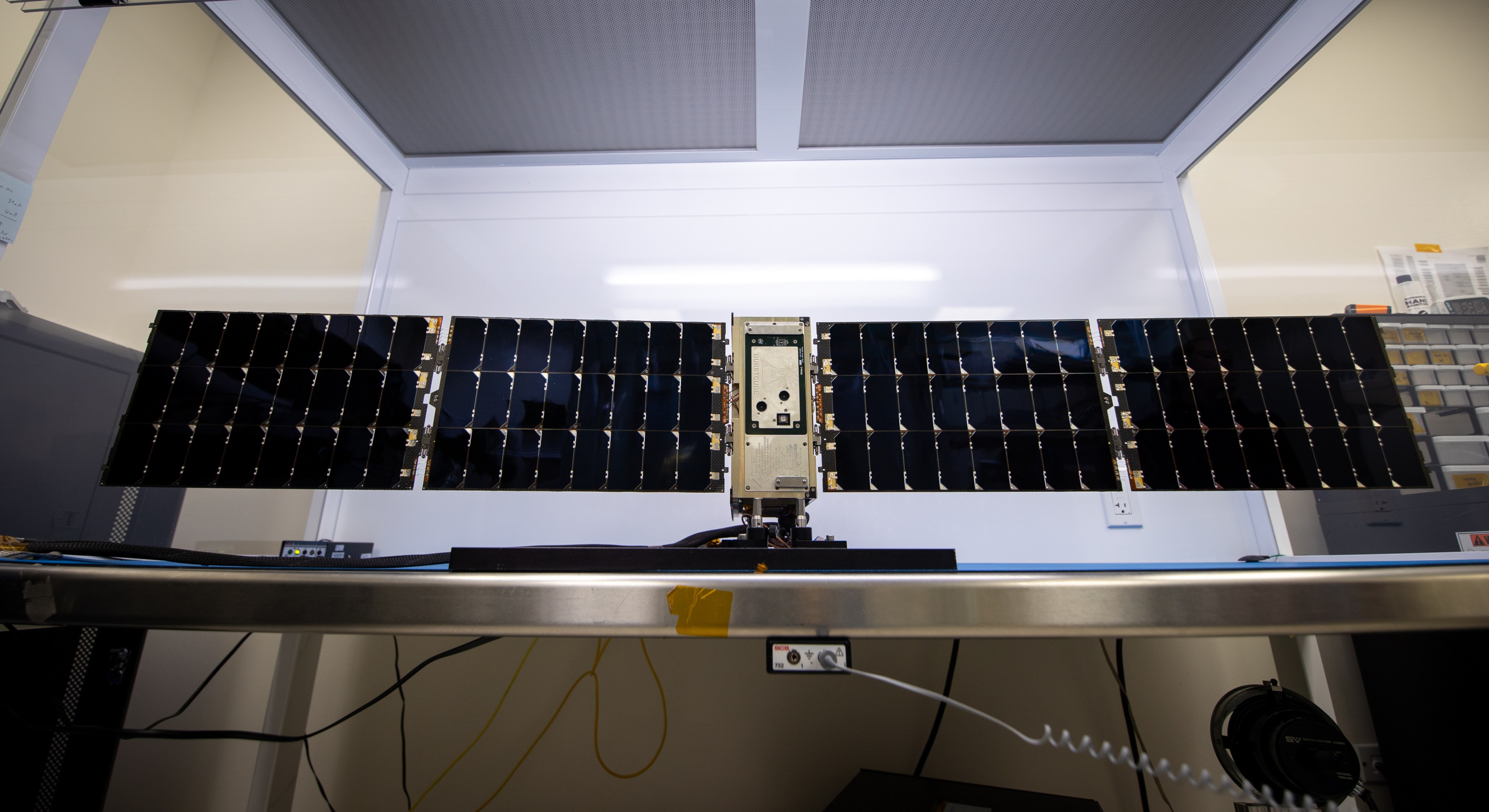 The BurstCube satellite sits on a table with its solar panels extended.