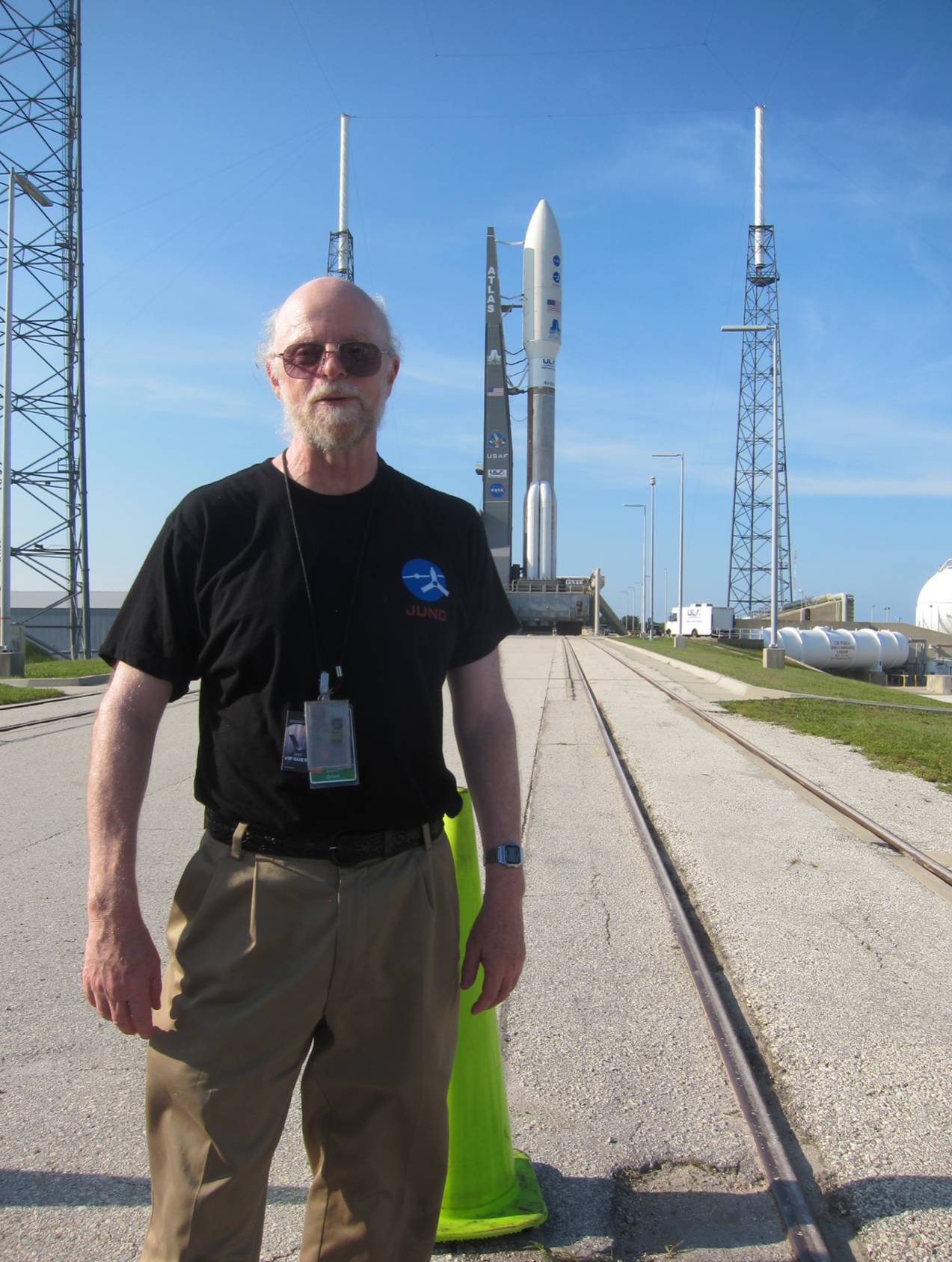 Photo of a man standing on a launchpad with a shuttle in the background