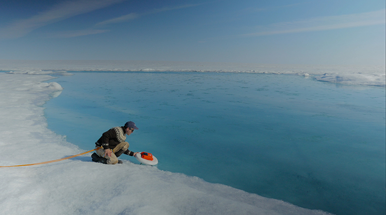 Laurence Smith (University of California, Los Angeles) deploys an autonomous drift boat equipped with several sensors in a meltwater river on the Greenland ice sheet. Credit: NASA's Goddard Space Flight Center/Jefferson Beck